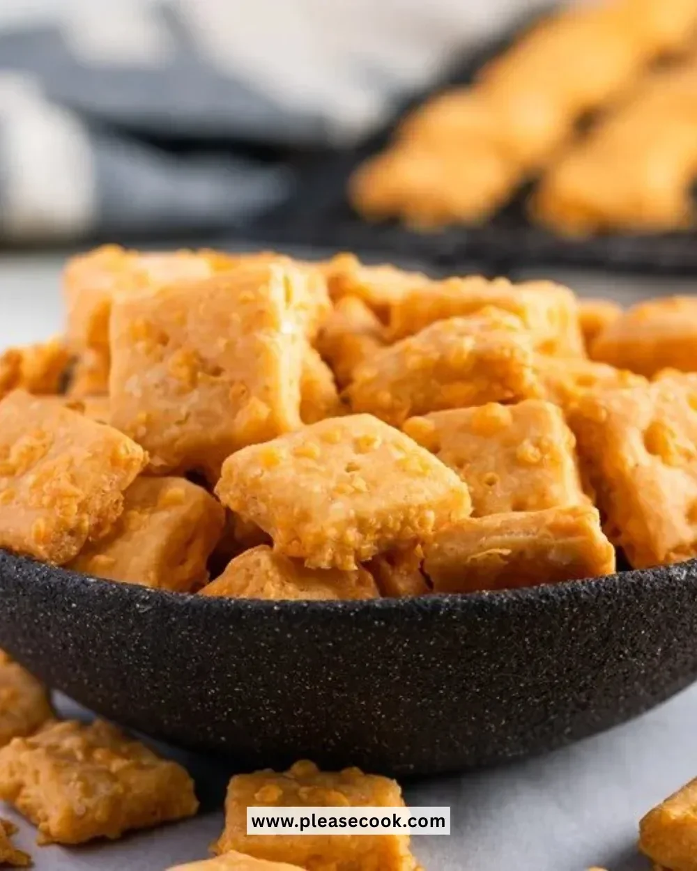 A plate of crispy gluten-free cheese crackers on a wooden table.