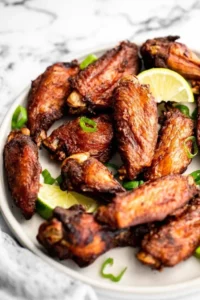 Deliciously spicy jerk chicken wings served with dipping sauce on a rustic platter.