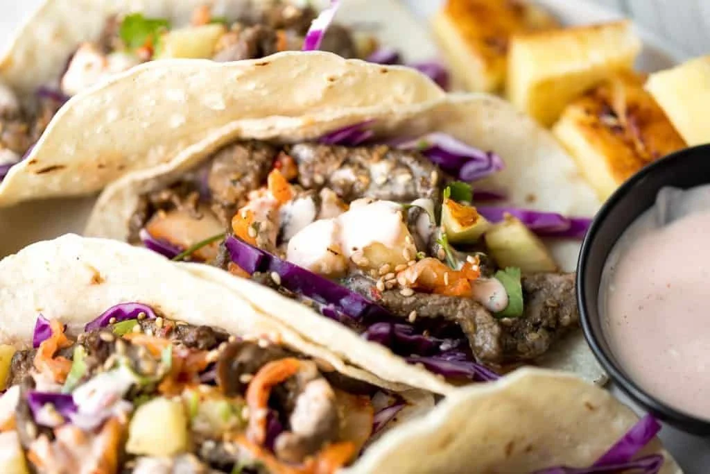 Korean beef steak tacos topped with fresh ingredients