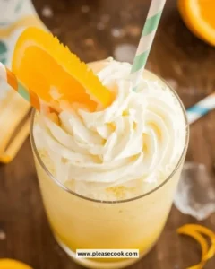 Refreshing Orange Cream Slushie in a glass with whipped cream and orange slice