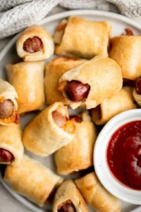 Platter of homemade pigs in a blanket served with dipping sauces