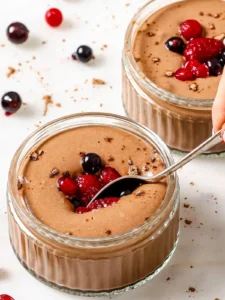 Bowl of creamy chocolate protein pudding topped with fresh berries