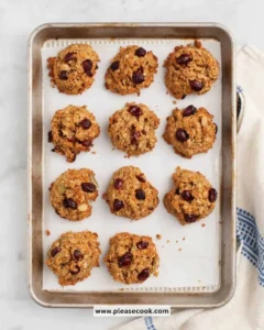 Baked quinoa breakfast cookies with nuts and chocolate chips on a baking tray.