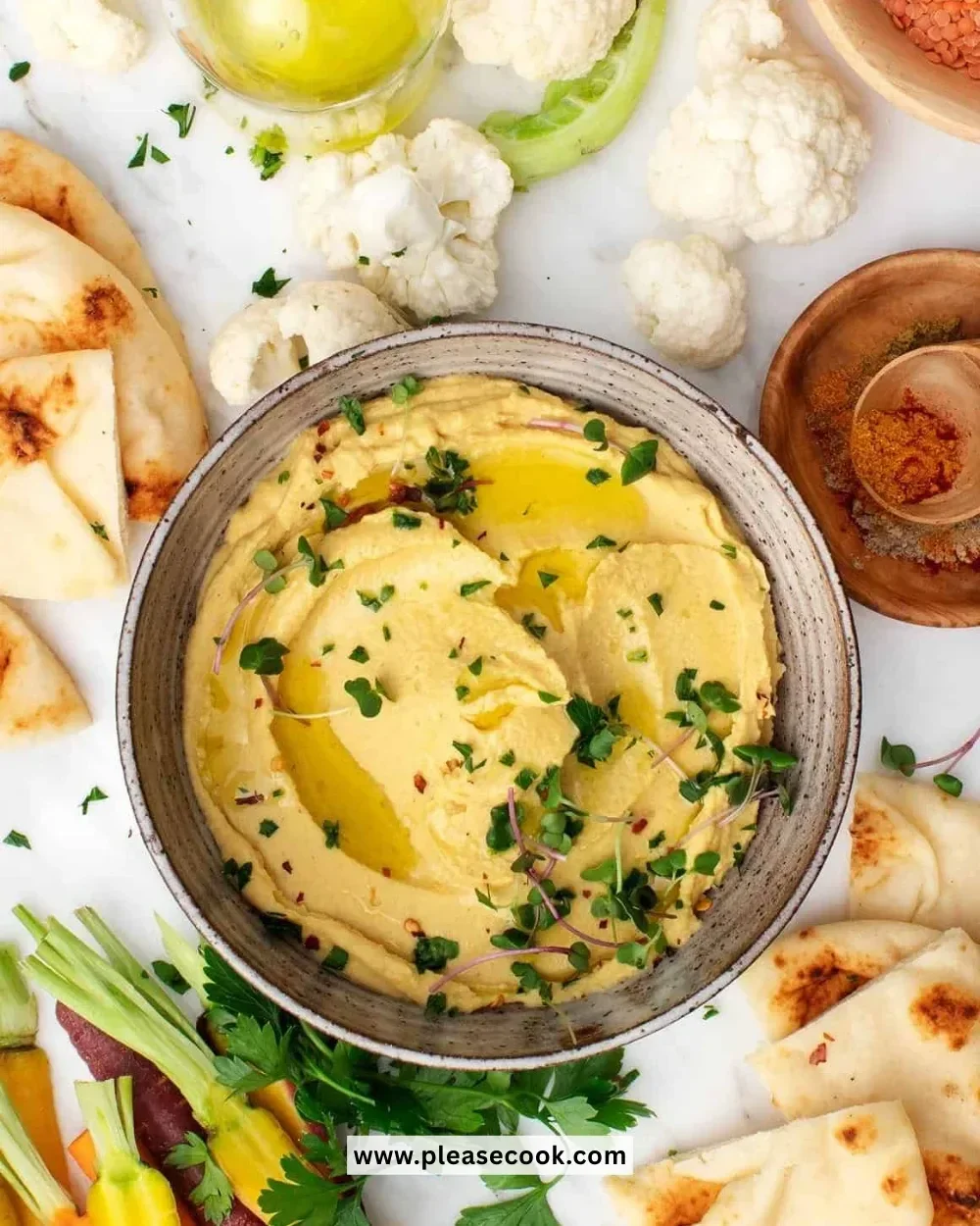Bowl of creamy Red Lentil Hummus garnished with olive oil and herbs