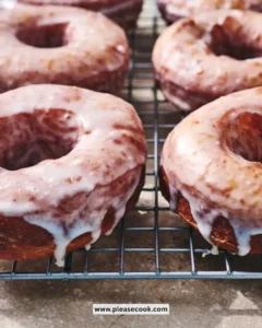 Freshly made sourdough doughnuts topped with icing and sprinkles.