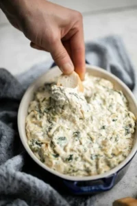 Creamy Spinach Artichoke Dip served in a bowl with tortilla chips