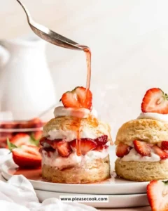 Slice of strawberry shortcake topped with fresh strawberries and whipped cream