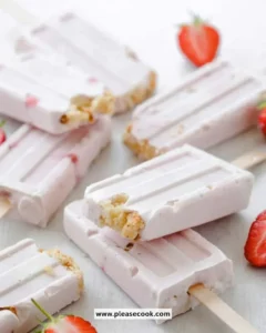 Sugar free strawberry cheesecake popsicles in a vibrant summer setting