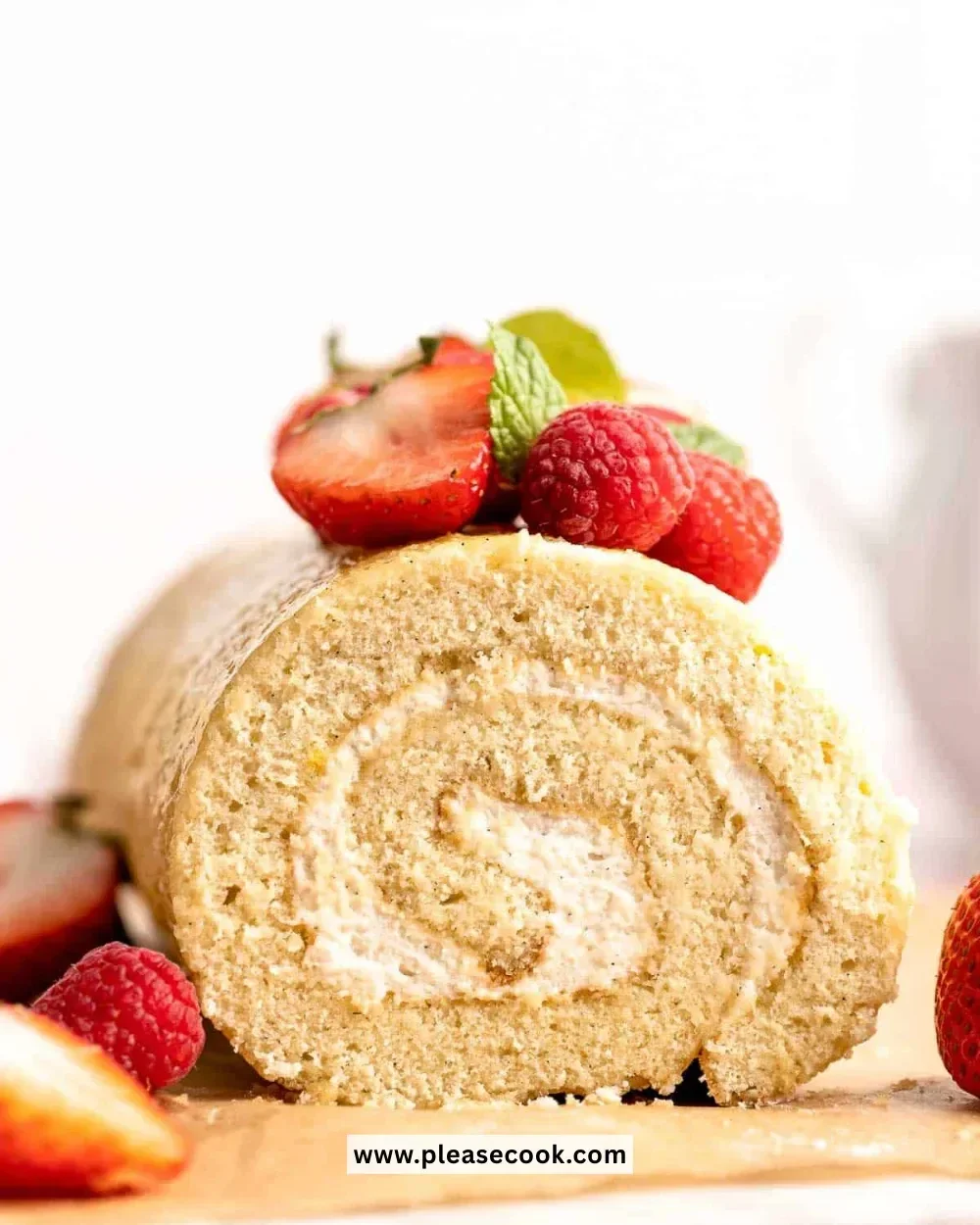 Delicious Vanilla Swiss Roll Cake garnished with cream and berries