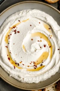 Delicious whipped feta served as a dip on a platter with fresh vegetables.