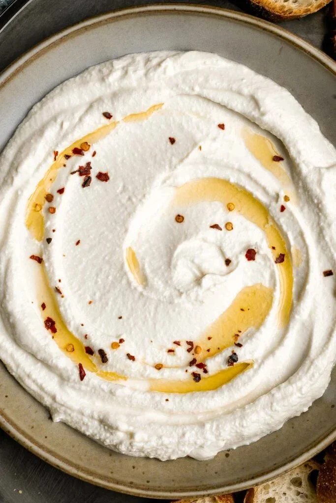 Delicious whipped feta served as a dip on a platter with fresh vegetables.