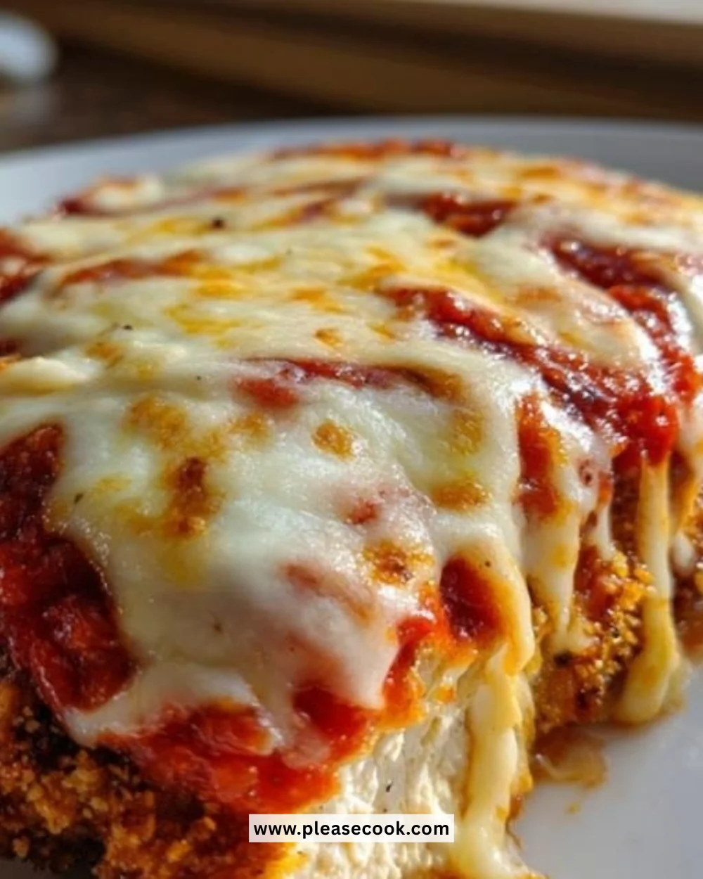 Baked Chicken Parmesan served with spaghetti and garnished with fresh basil