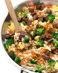 Delicious beef fried rice served in a bowl with vegetables and herbs