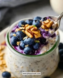 Bowl of blueberry overnight oats with yogurt and fresh blueberries