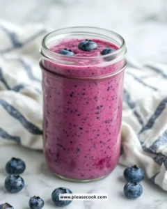 Delicious blueberry smoothie in a glass with fresh blueberries and mint