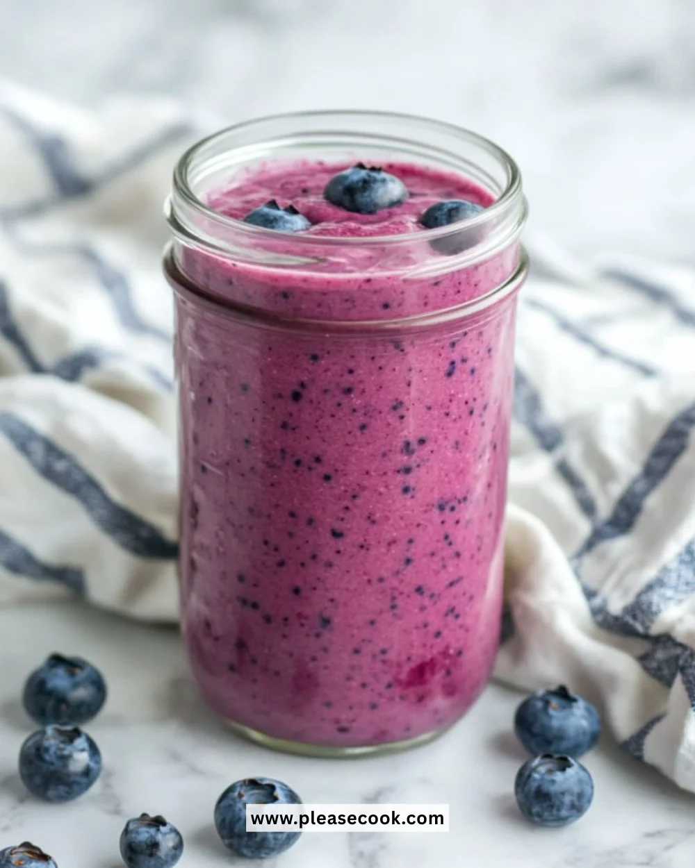Delicious blueberry smoothie in a glass with fresh blueberries and mint