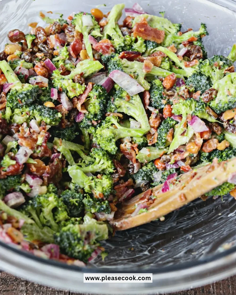 Broccoli salad with bacon served in a bowl, topped with dressing.