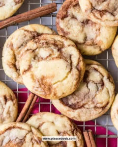 Freshly baked cinnamon cookies on a cooling rack.