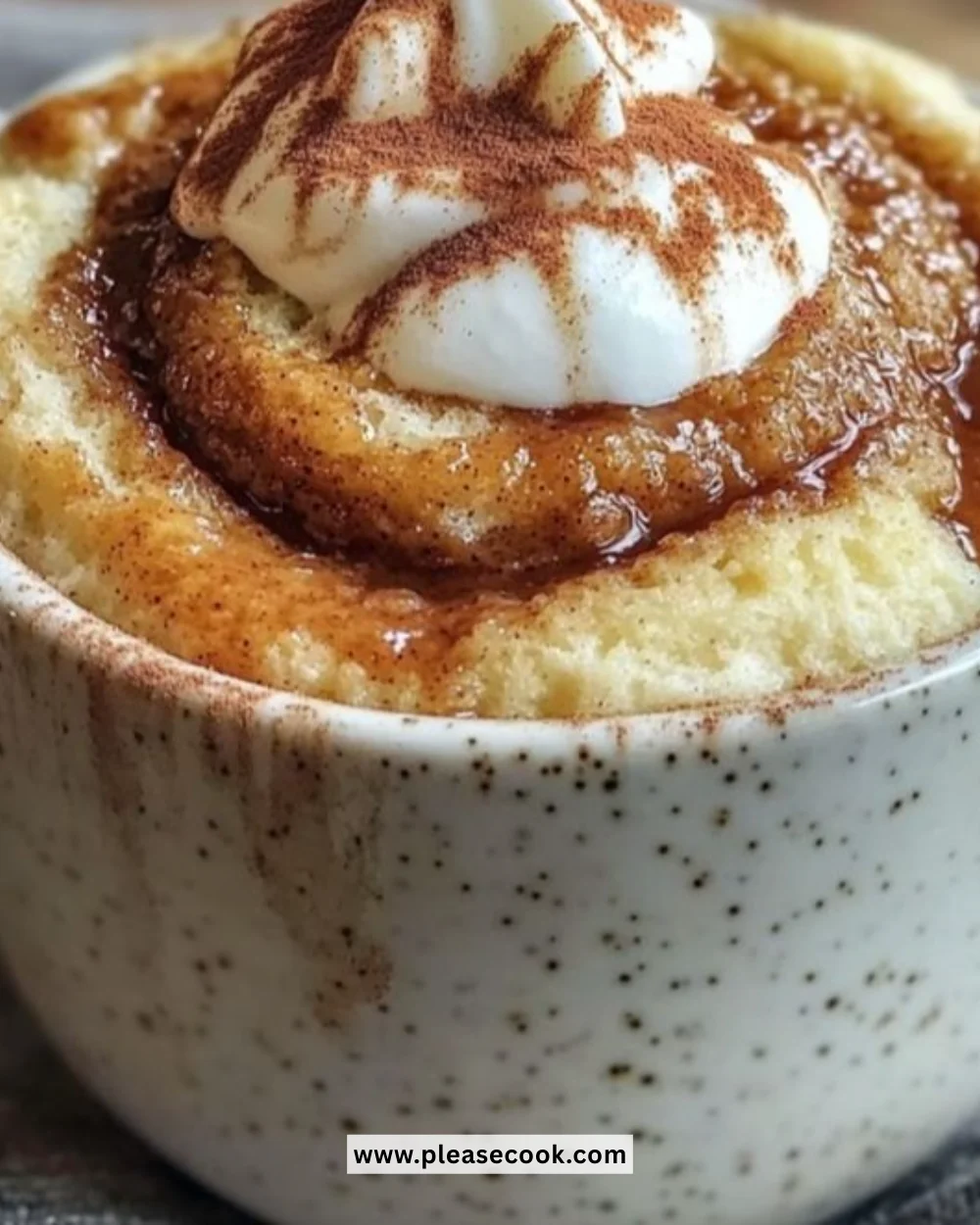 Cottage Cheese Cinnamon Roll Mug Cake served in a mug with a cinnamon sprinkle on top