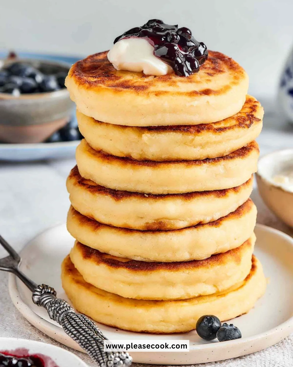 Fluffy cottage cheese pancakes served with syrup and fruit
