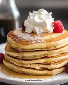 Fluffy low-carb pancakes served on a plate with syrup and berries