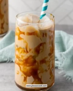 Homemade caramel iced coffee in a glass with a straw and caramel drizzle