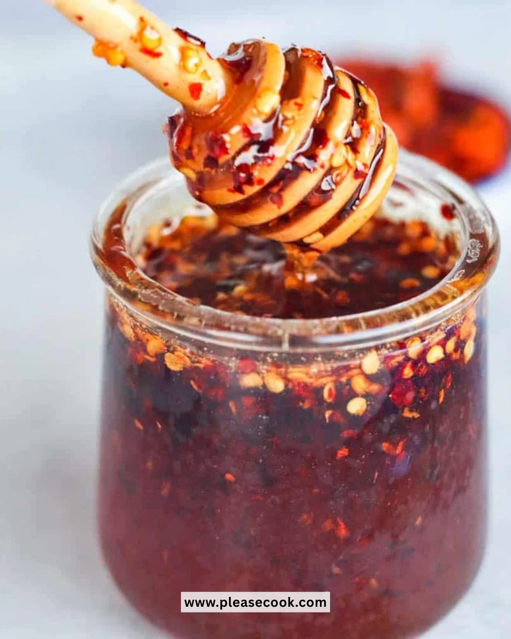 A jar of hot honey with a drizzle, showcasing its spicy-sweet flavor perfect for dishes.