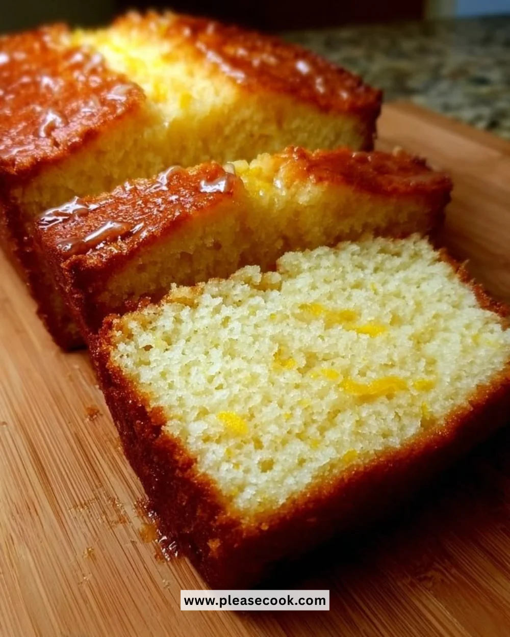 Moist keto lemon bread slice with a lemon wedge on a plate
