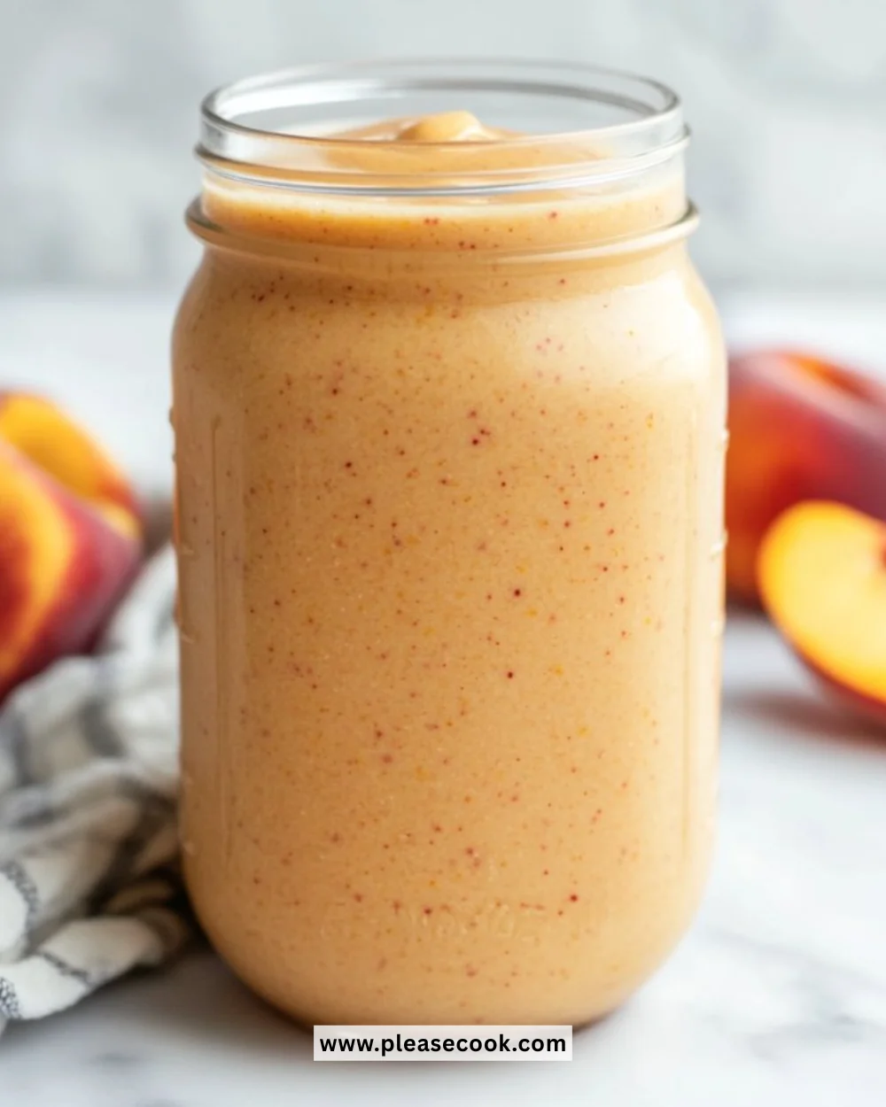 Delicious homemade Vanilla Peach Smoothie in a glass with fresh peaches