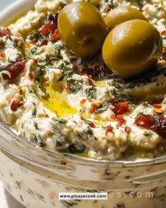 Bowl of easy olive dip garnished with herbs and served with crackers.
