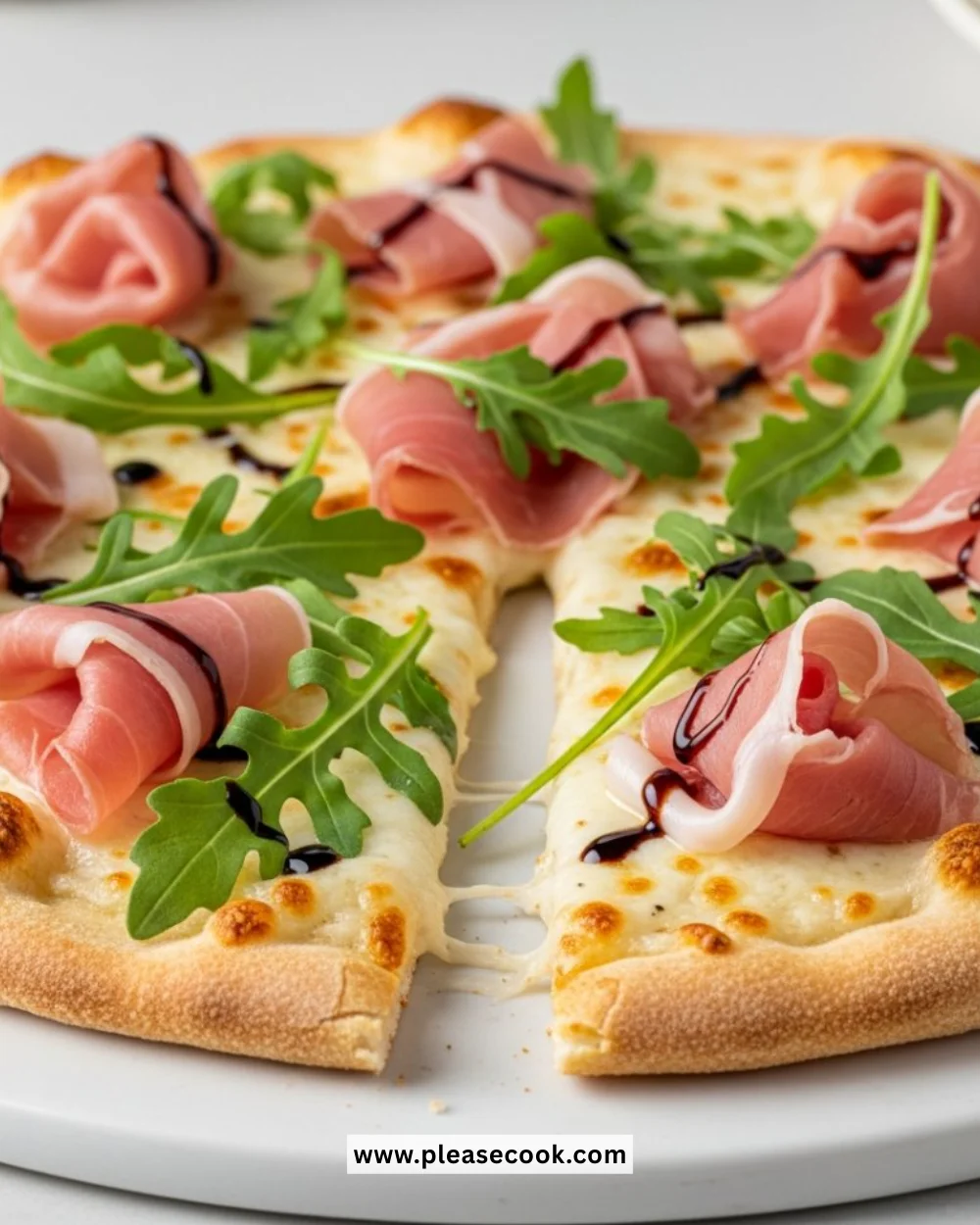 Slice of easy prosciutto white pizza topped with fresh ingredients