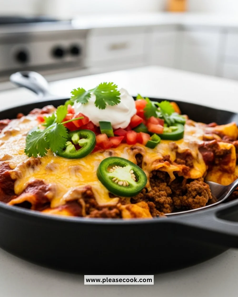Ground beef enchilada skillet topped with cheese and fresh ingredients