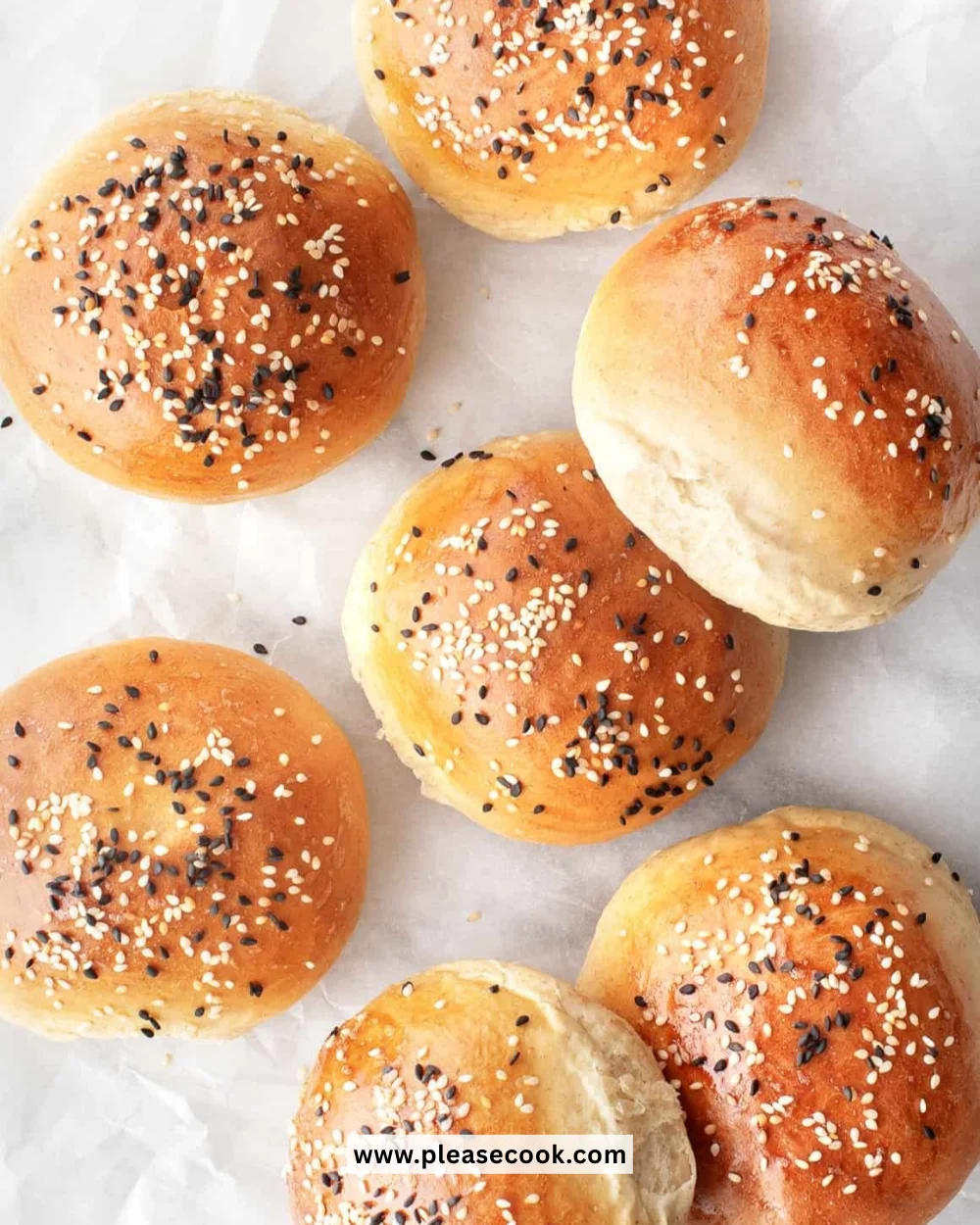Homemade hamburger buns ready for burgers on a wooden table