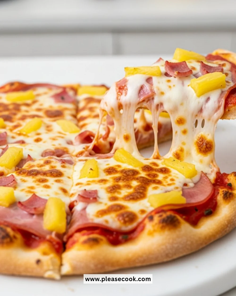 Homemade Hawaiian pizza topped with cheese, ham, and pineapple slices.