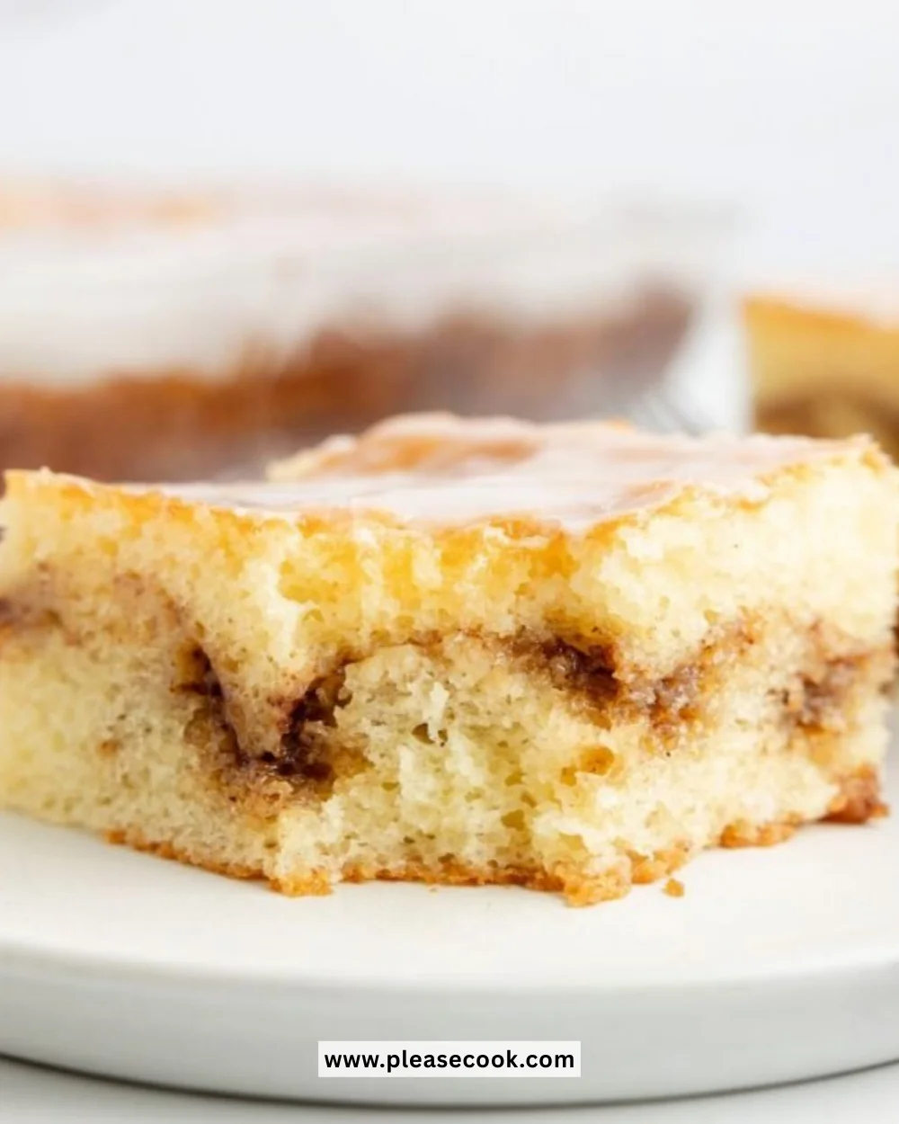 Delicious Honey Bun Cake with glaze and cinnamon topping on a plate.
