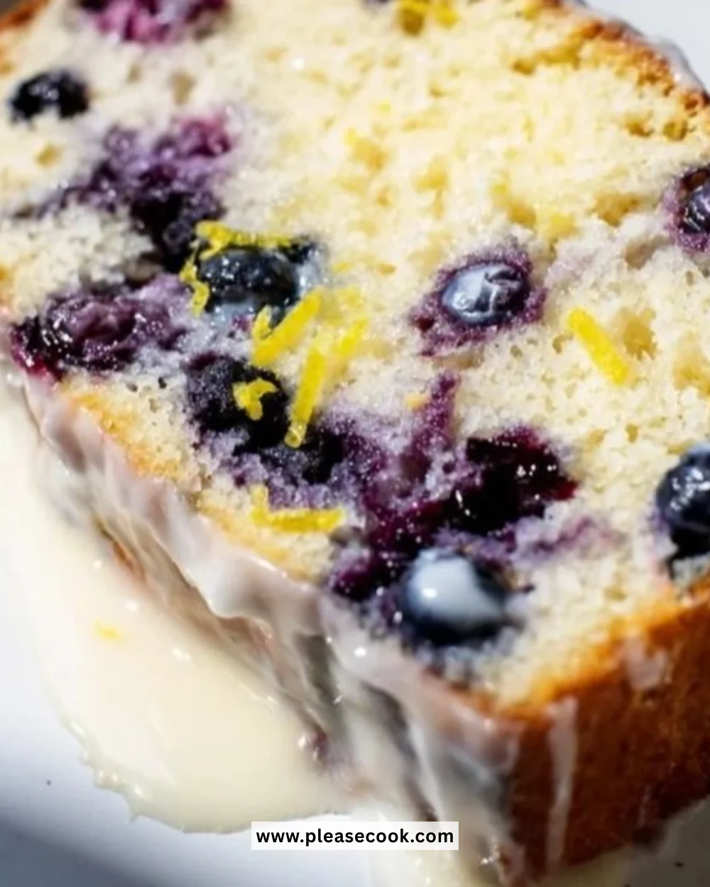 Lemon blueberry yogurt loaf slice on a plate, garnished with fresh blueberries.