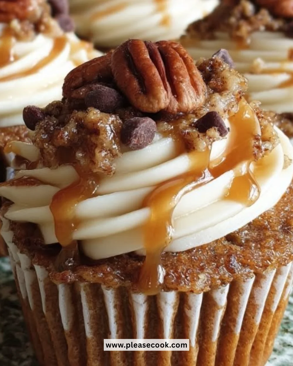 Pecan pie pumpkin cupcakes topped with creamy frosting and pecans
