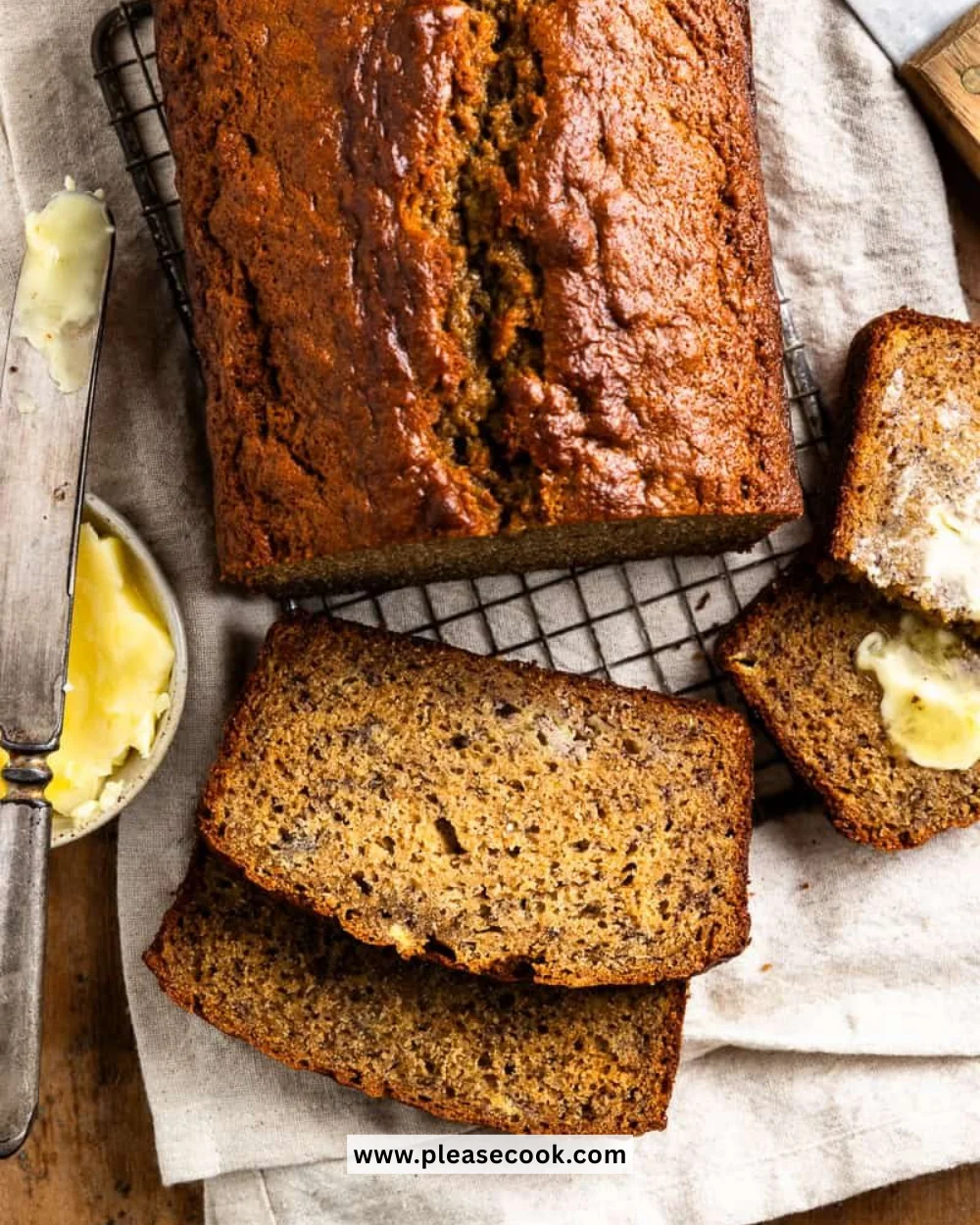 A loaf of freshly baked sourdough banana bread on a wooden cutting board.