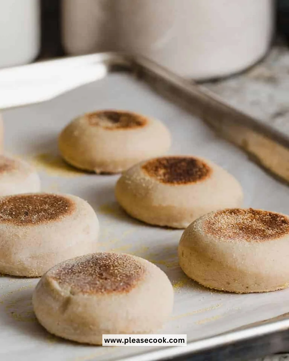 Freshly baked sourdough English muffins cooling on a wire rack