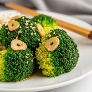 Plate of delicious broccoli coated in garlic sauce, garnished for flavor.