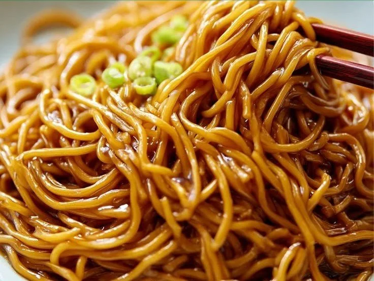 Homemade Lo Mein noodles served with fresh vegetables and sauce.