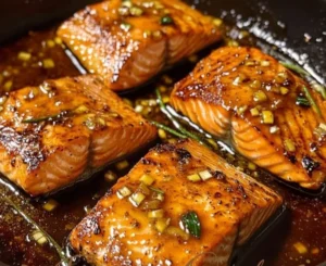 Delicious honey garlic glazed salmon fillet on a plate garnished with herbs