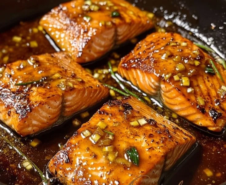 Delicious honey garlic glazed salmon fillet on a plate garnished with herbs