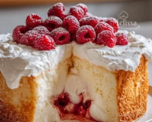 Delicious Raspberry Angel Food Cake topped with fresh raspberries and whipped cream.