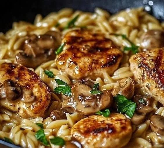 Plate of savory Marsala chicken served with creamy orzo pasta