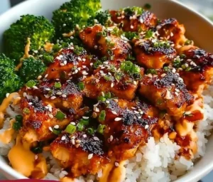 Delicious Sticky Chicken Rice Bowls topped with fresh herbs and vibrant vegetables.