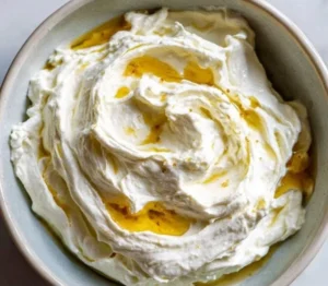 Delicious whipped feta dip served in a bowl, garnished with herbs.