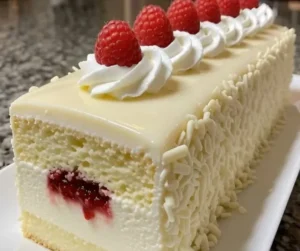 White Chocolate Raspberry Mousse Cake with fresh raspberries and chocolate on top