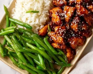 Plate of Asian High Protein Sesame Chicken garnished with sesame seeds and vegetables