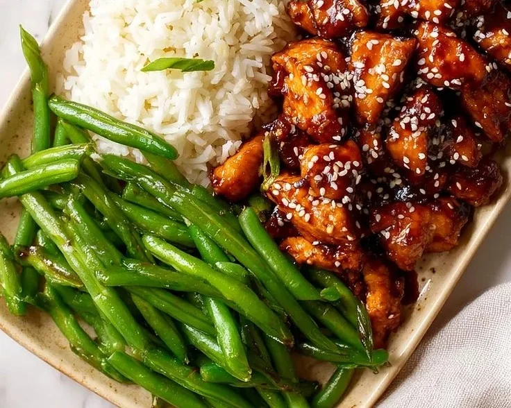 Plate of Asian High Protein Sesame Chicken garnished with sesame seeds and vegetables